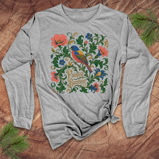 Gray long-sleeve shirt with colorful bird and floral design on a wooden surface