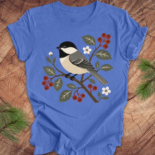 Blue t-shirt with a chickadee design on a wooden surface