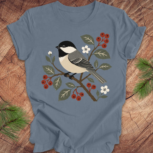 Blue t-shirt with a chickadee design on a wooden surface