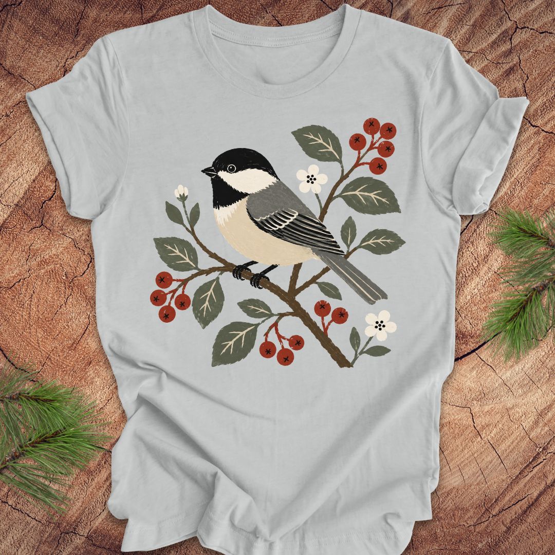 Gray t-shirt with a chickadee and berry design on a wooden surface