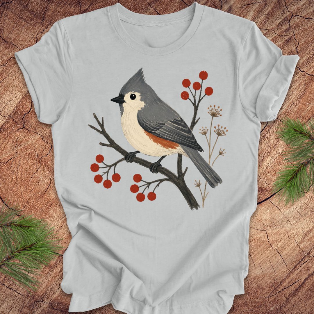 Gray t-shirt with a titmouse and berries design on a wood background.