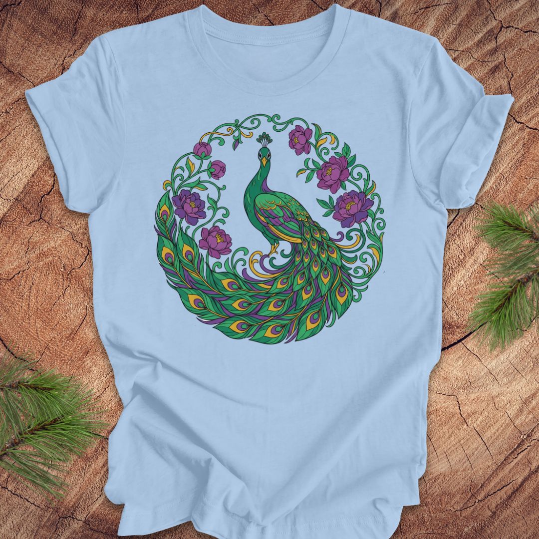 Light blue t-shirt with a peacock and flowers design on a wooden surface