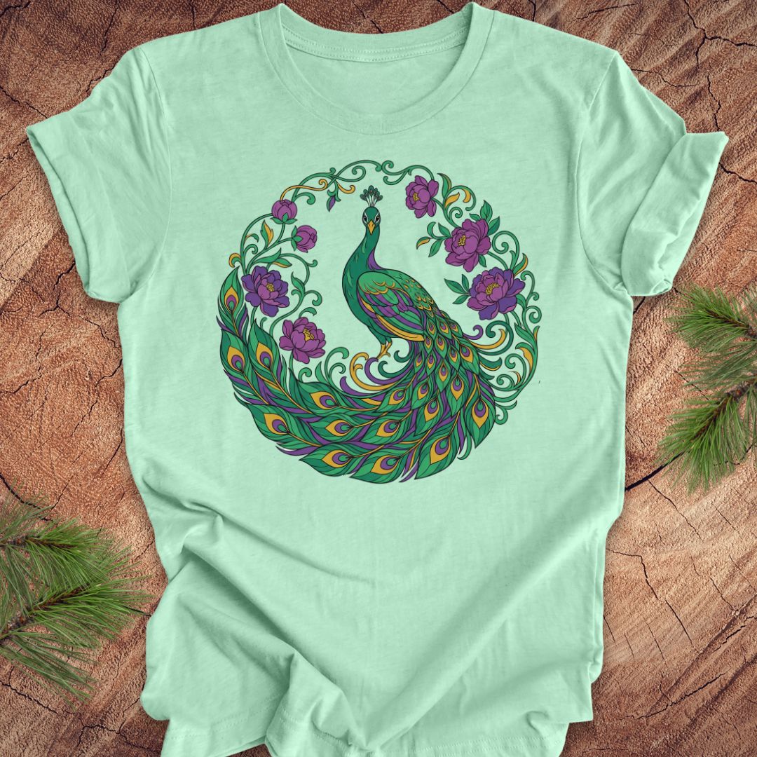 Mint green t-shirt with a peacock and flowers design on a wooden surface