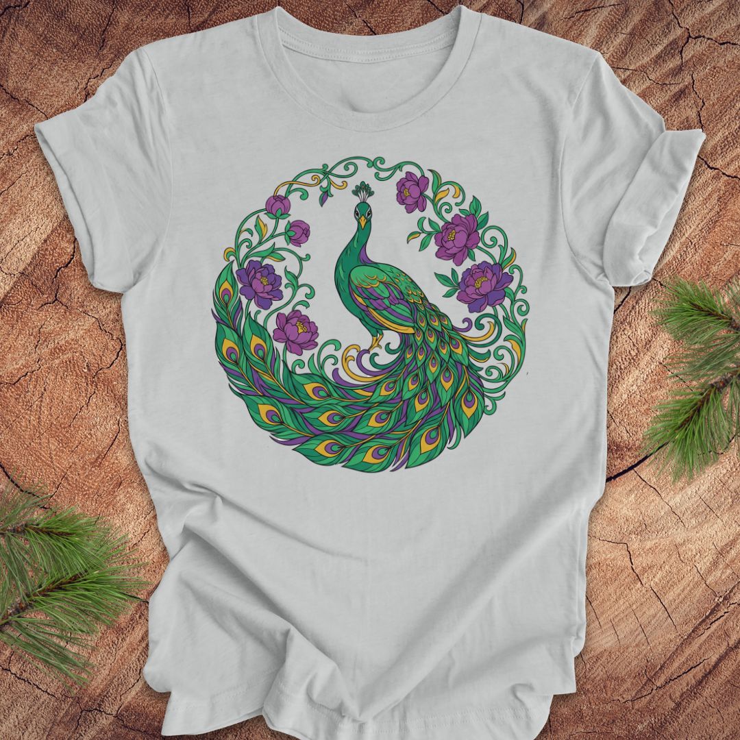 Gray t-shirt with a peacock and flowers design on a wooden surface