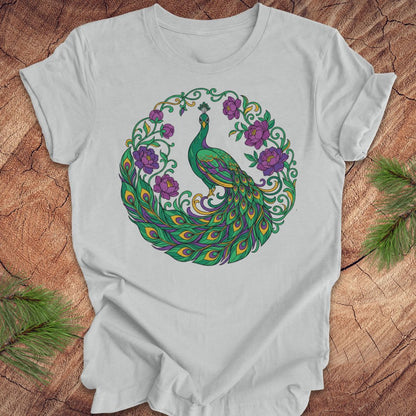 Gray t-shirt with a peacock and flowers design on a wooden surface