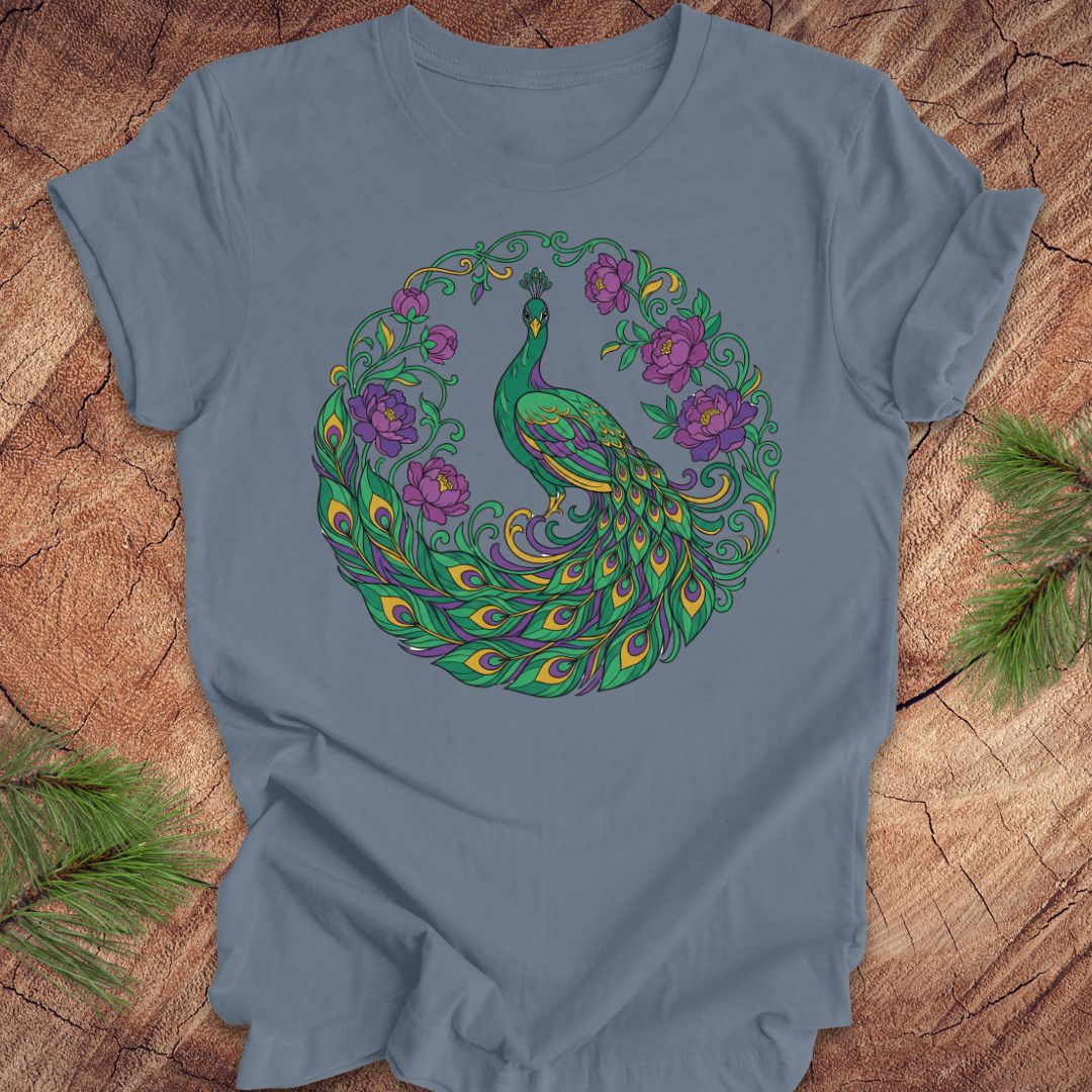 Blue t-shirt with a peacock and flowers design on a wooden surface