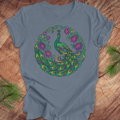 Blue t-shirt with a peacock and flowers design on a wooden surface