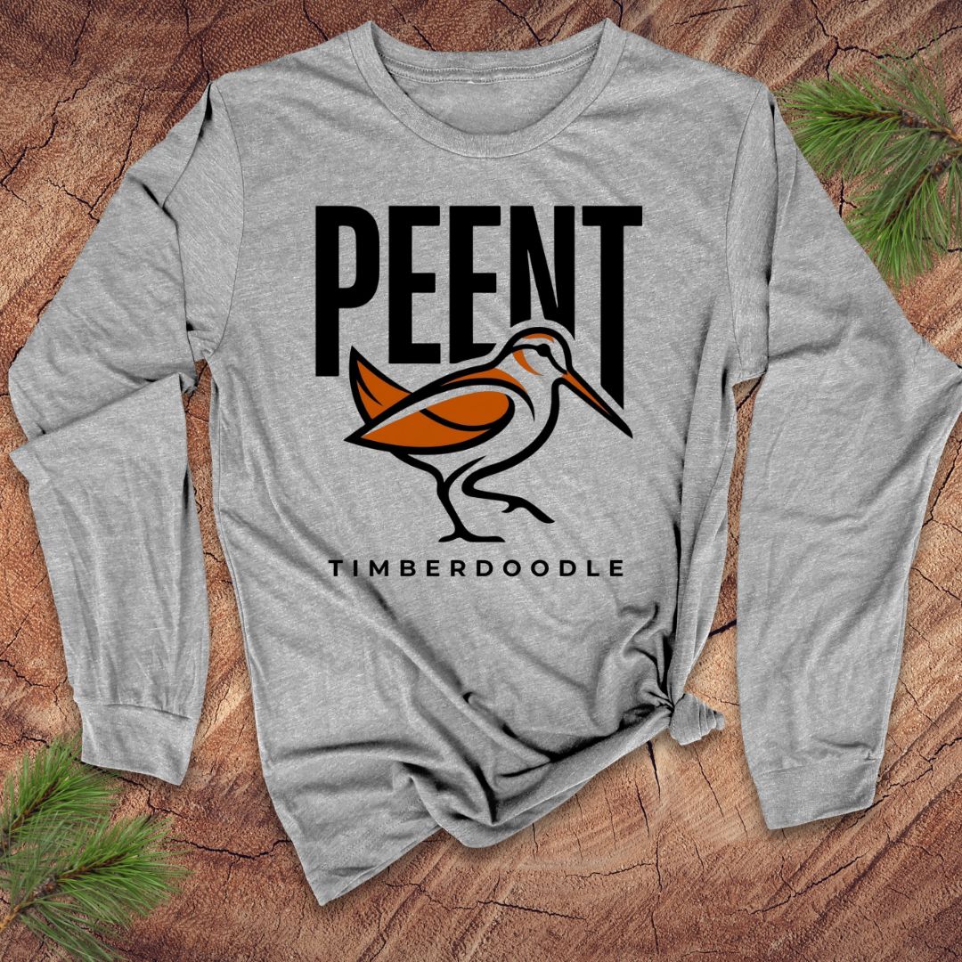 Gray long-sleeve shirt with 'PEENT TIMBERDOODLE' design on a wooden surface