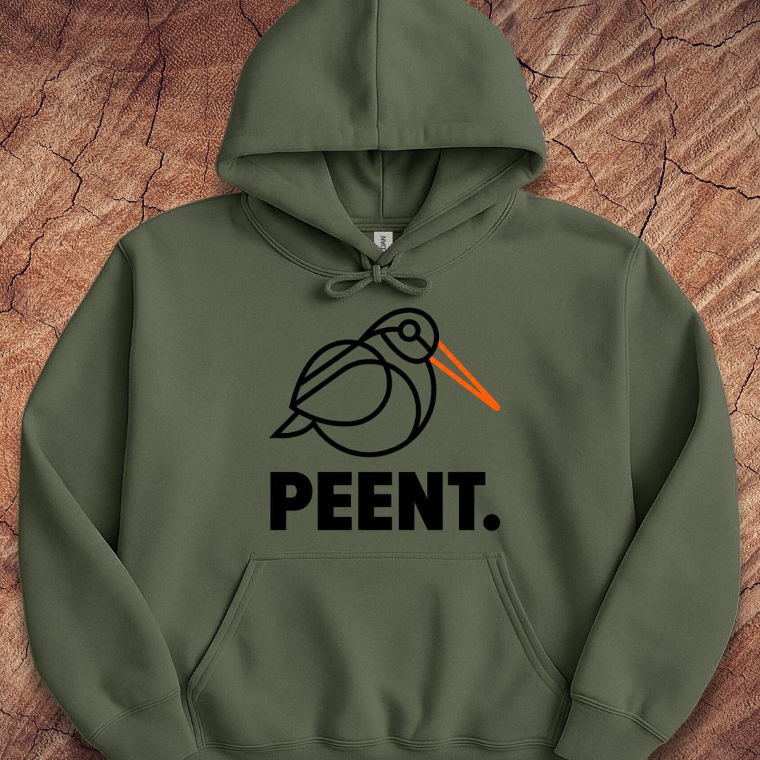 An olive green pullover hoodie with a graphic of a stylized black bird with an orange beak and the word 'PEENT.' printed below in black, laid flat on a textured brown wood background.