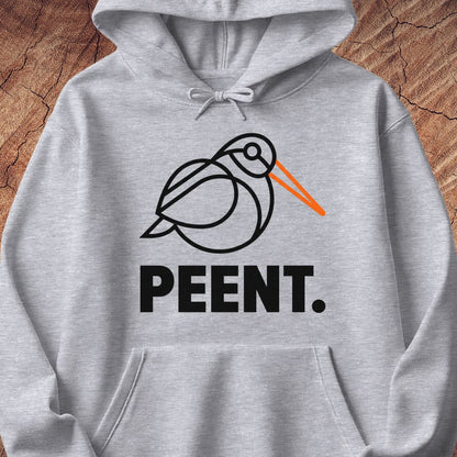 A light heather gray pullover hoodie featuring a black line art graphic of a bird with an orange beak and the word 'PEENT.' printed below in bold black letters, displayed against a rustic wood background.