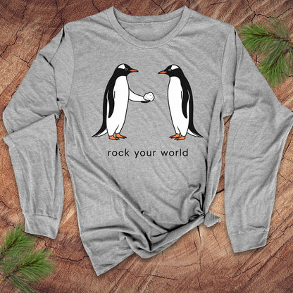 Gray long-sleeve t-shirt with penguins and text 'rock your world' on a wood background.