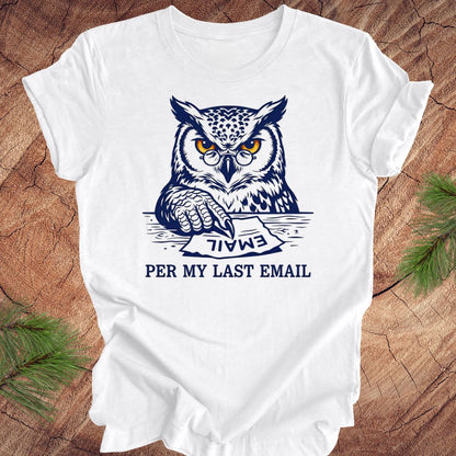 White t-shirt with an owl graphic and text, 'per my last email' on a wooden surface