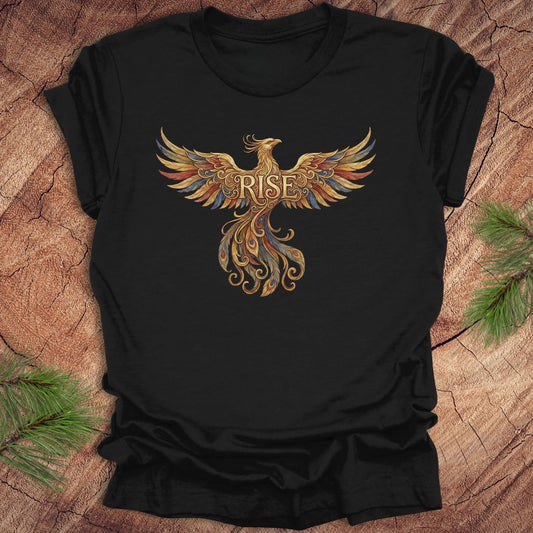 Black t-shirt with a colorful phoenix design and 'RISE' text on a wooden surface.