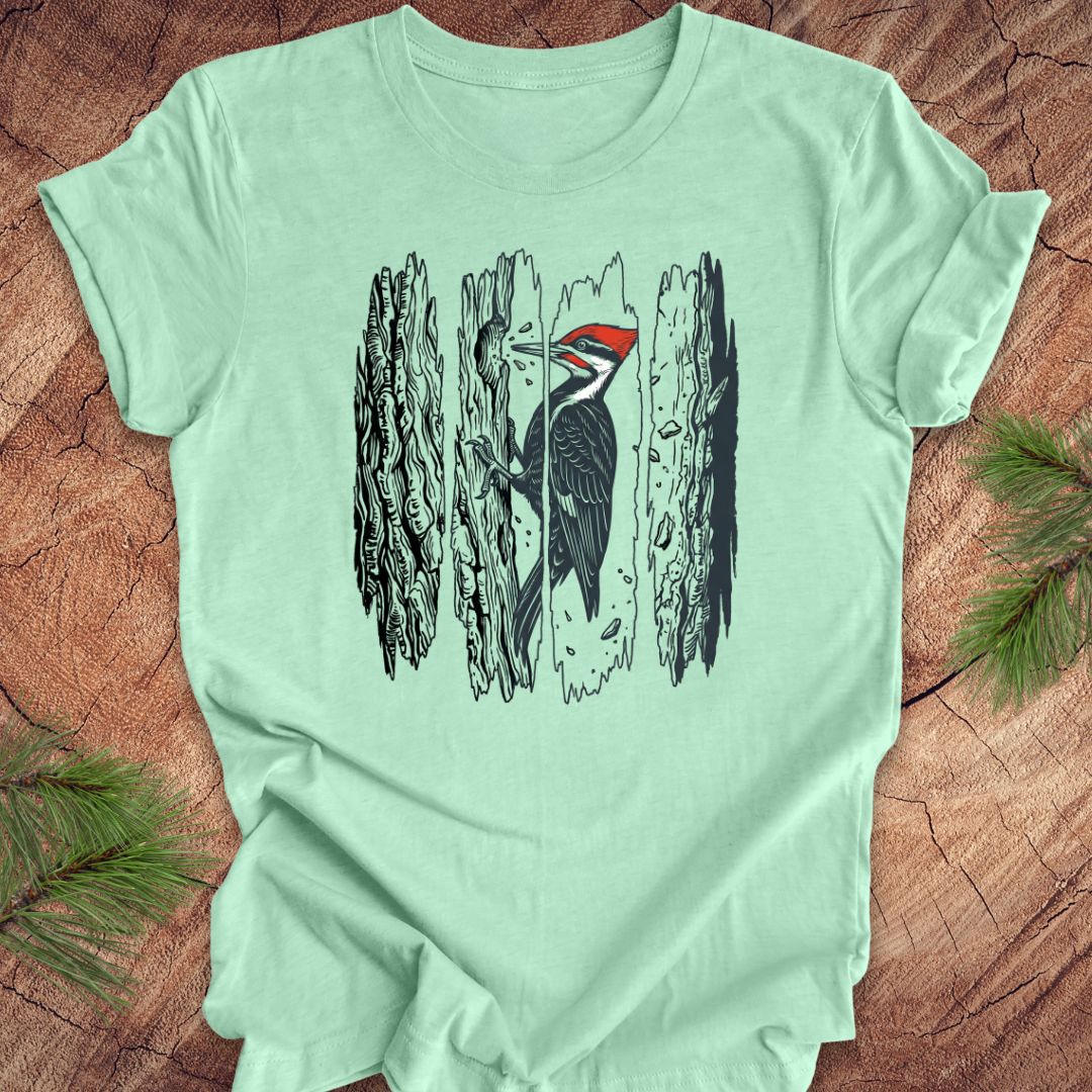 Light green t-shirt with a woodpecker design on a wooden surface
