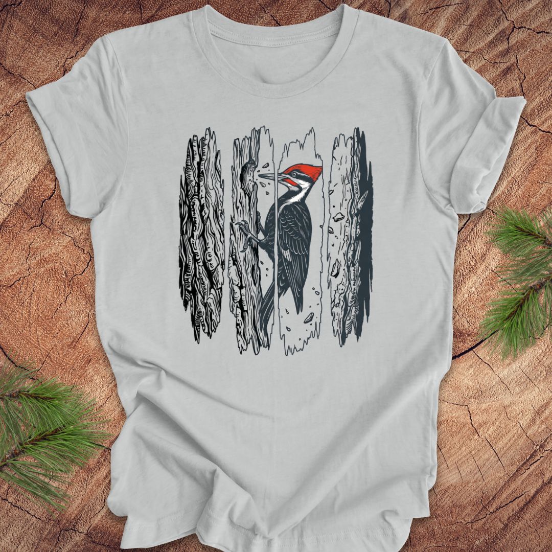 Gray t-shirt with a woodpecker design on a wooden surface