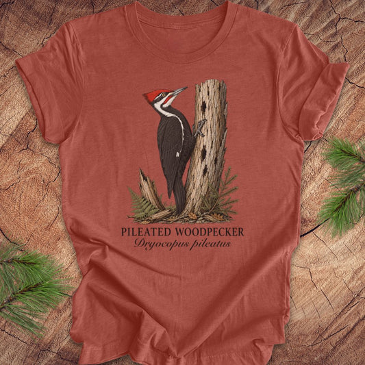 Red t-shirt with a pileated woodpecker graphic on a wooden surface