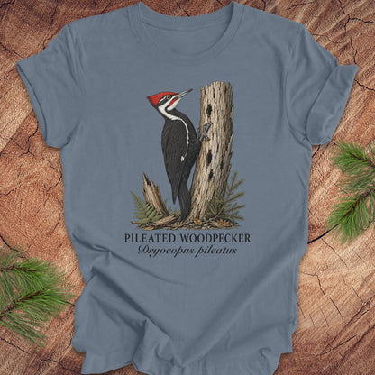 Blue t-shirt with a pileated woodpecker design on a wooden background