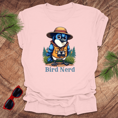 Pink-shirt with an animated blue jay in birdwatching gear with "bird nerd" text on a wood background.