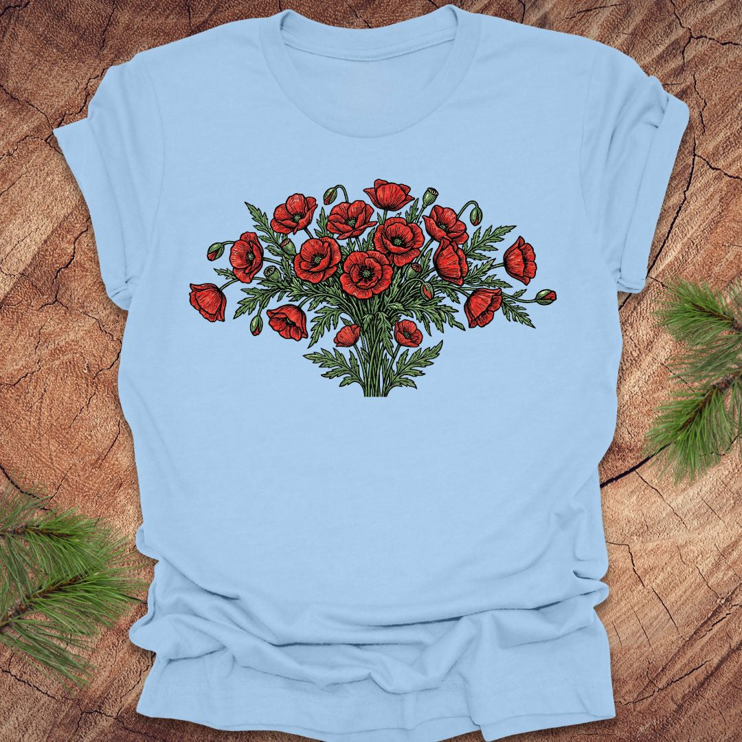 Baby blue t-shirt with red poppy bouquet design on a wooden surface