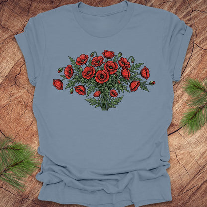 Steel blue t-shirt with red poppy bouquet design on a wooden surface