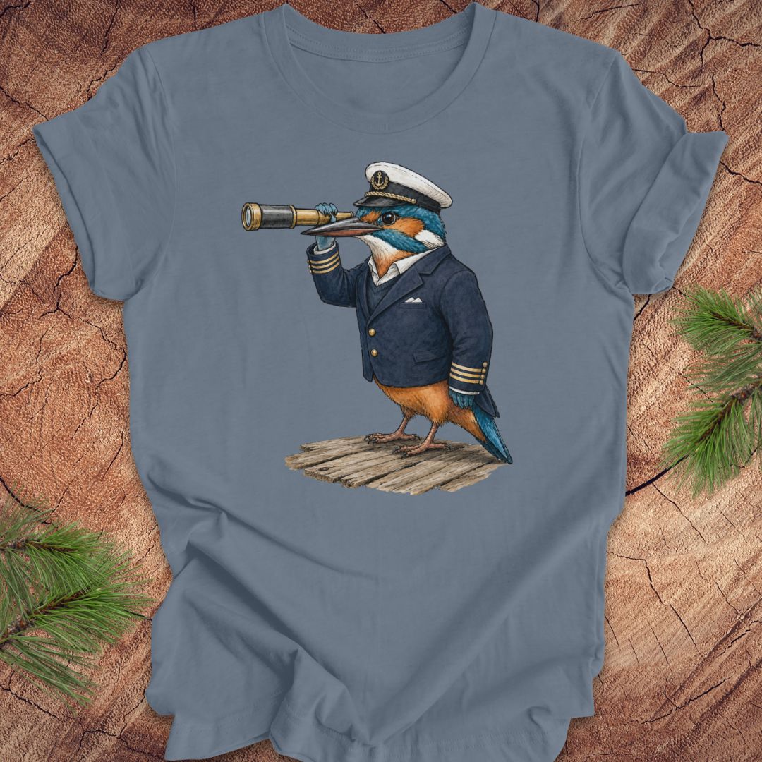 Blue t-shirt with a kingfisher bird in a captain's outfit and spyglass on a wooden surface.