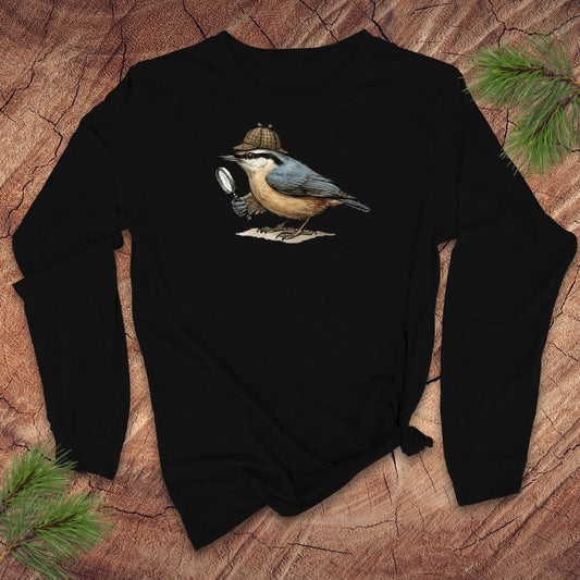 Black long-sleeve shirt with a nuthatch bird with a Sherlock Holmes hat and magnifying glass graphic on a wooden surface
