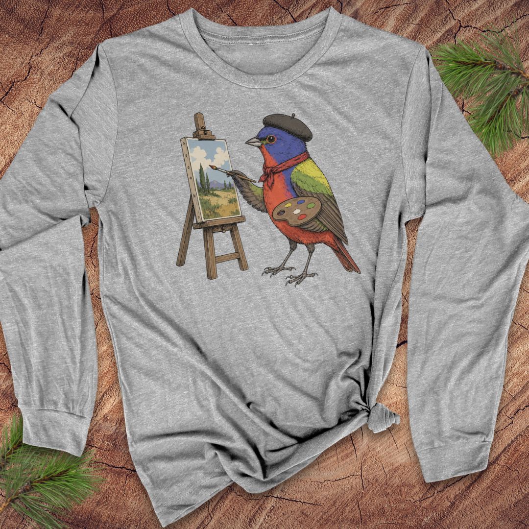 Athletic heather gray long-sleeve t-shirt with a Painted Bunting in a black beret and red scarf, painting a landscape at a tiny easel, laid flat on a rustic wood background with pine branches.