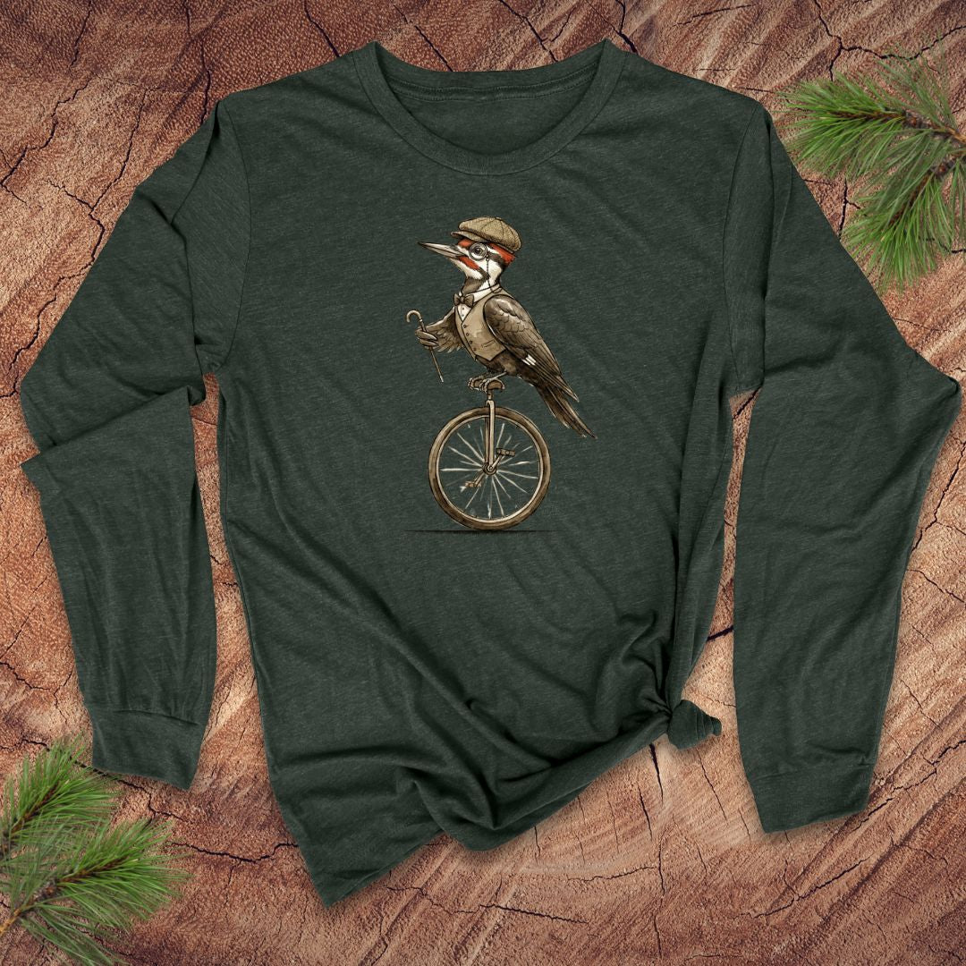 Green long-sleeve shirt with a woodpecker on a unicycle design on a wooden surface.