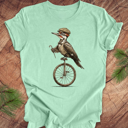 Mint green t-shirt with a woodpecker design on a wooden surface