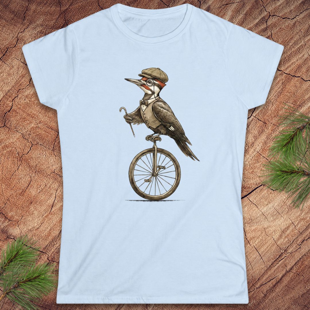 Light blue t-shirt with a woodpecker on a unicycle graphic on a wooden surface.