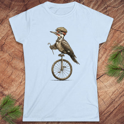 Light blue t-shirt with a woodpecker on a unicycle graphic on a wooden surface.