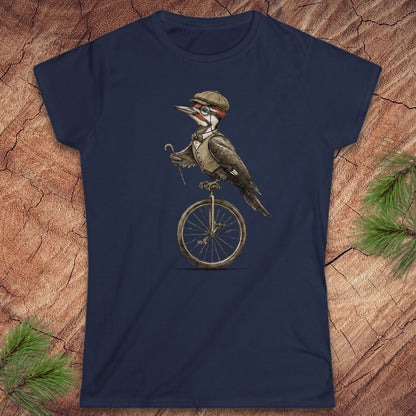 Navy blue t-shirt with a woodpecker on a unicycle design on a wooden surface.