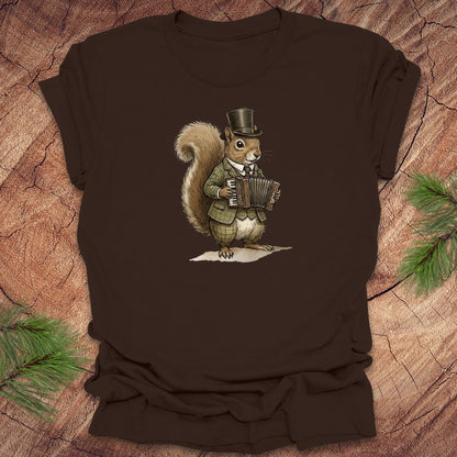 Brown t-shirt with a well dressed squirrel playing an accordion graphic on a wooden surface.