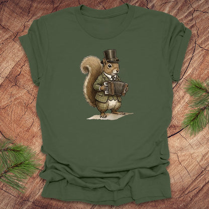 Military green t-shirt with a well dressed squirrel playing an accordion graphic on a wooden surface.