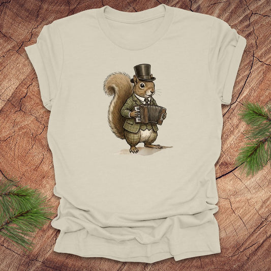 Beige t-shirt with a well dressed squirrel playing an accordion graphic on a wooden surface.