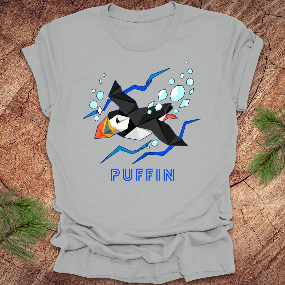 Gray t-shirt with a puffin graphic and 'PUFFIN' text on a wooden surface.