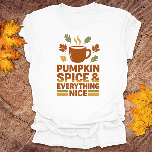 White t-shirt with 'Pumpkin Spice & Everything Nice' design on a wooden surface with fall leaves.