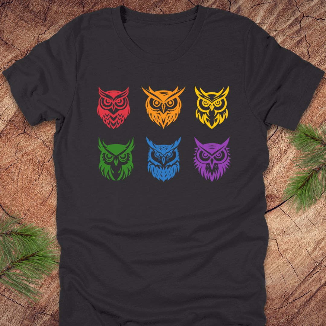 Dark grey t-shirt with 6 rainbow colored owl designs on a wooden surface