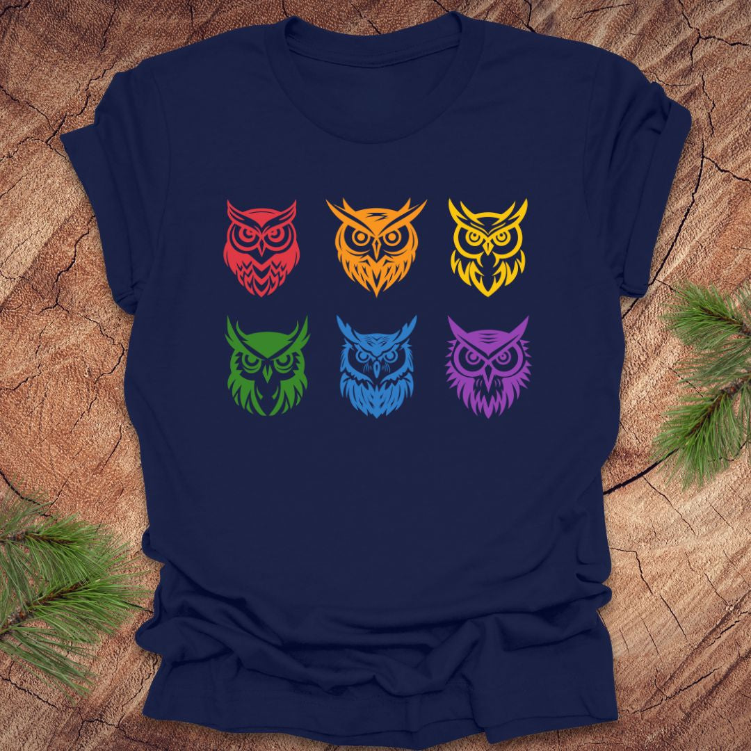 Navy blue t-shirt with 6 rainbow colored owl designs on a wooden surface