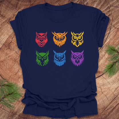 Navy blue t-shirt with 6 rainbow colored owl designs on a wooden surface