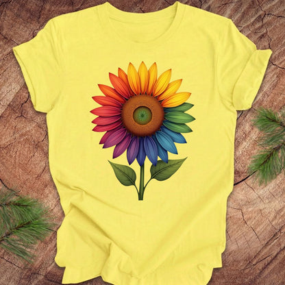Yellow t-shirt with a colorful sunflower design on a wooden surface.