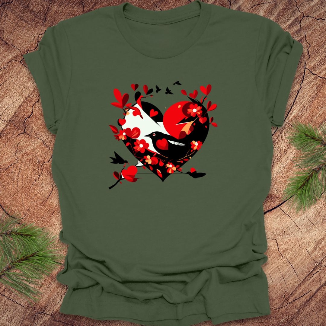 Freen t-shirt with a red and black heart with a raven inside of it, with red hearts flying off of it, on a wooden background.