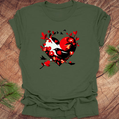 Freen t-shirt with a red and black heart with a raven inside of it, with red hearts flying off of it, on a wooden background.
