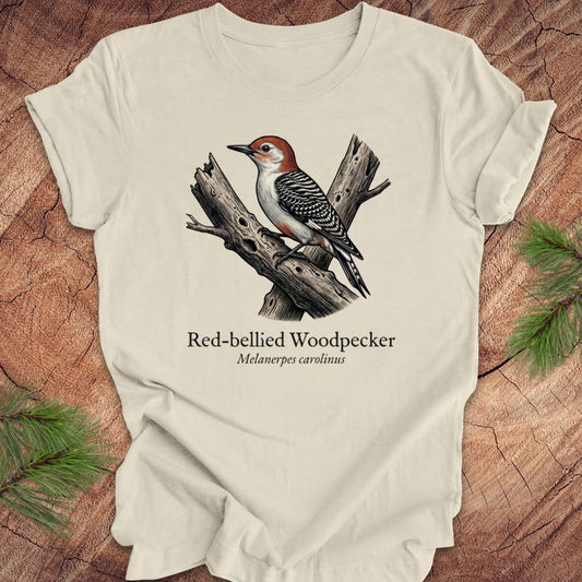 Beige t-shirt with red-bellied woodpecker graphic and text on a wooden surface
