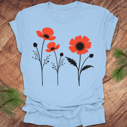 Baby blue t-shirt with red floral poppy design on a wooden surface