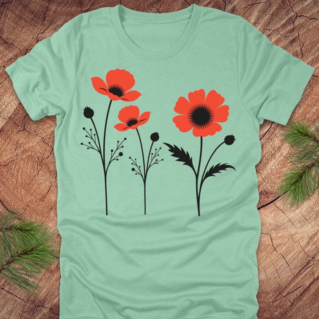 Mint green t-shirt with red floral poppy design on a wooden surface