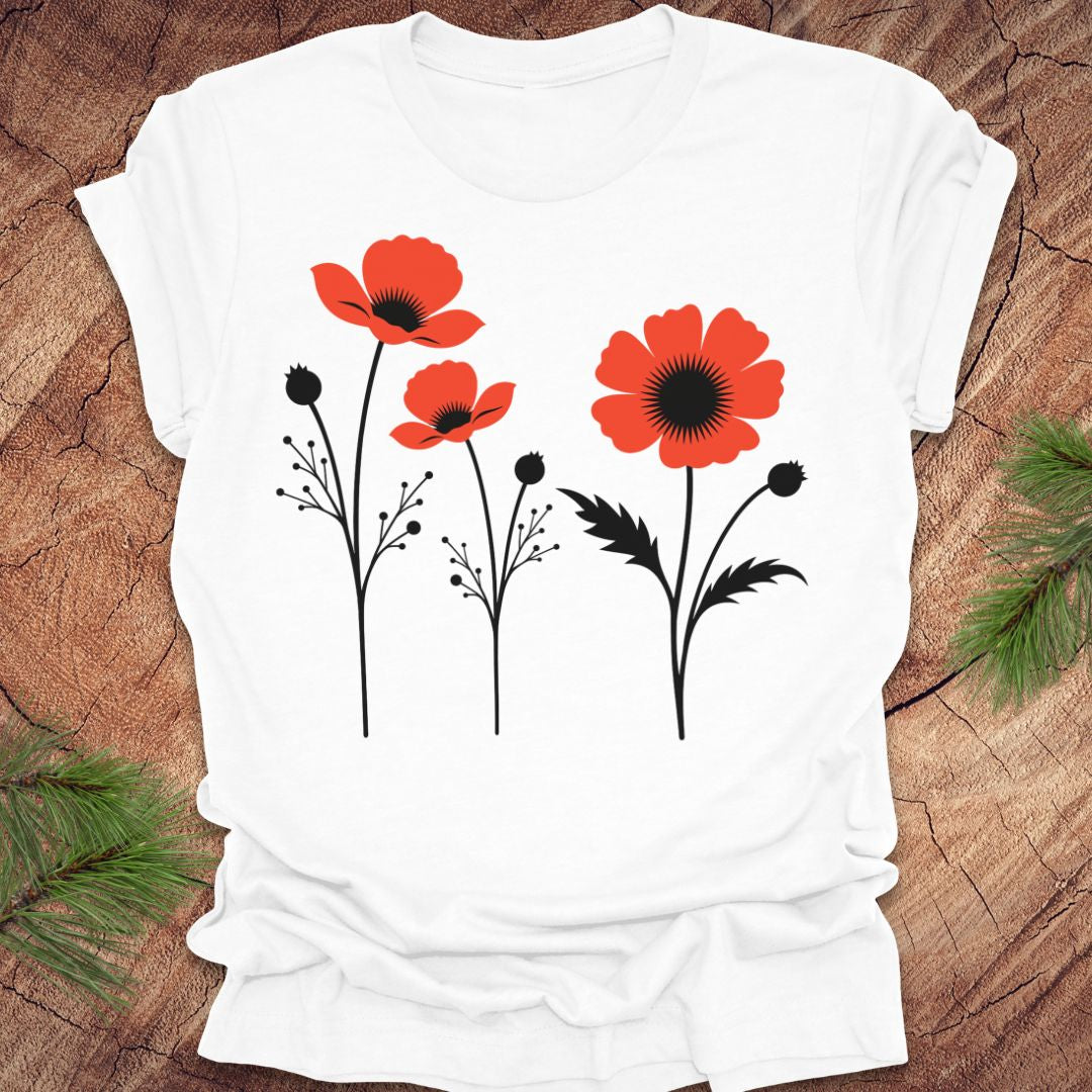 White t-shirt with red floral poppy design on a wooden surface
