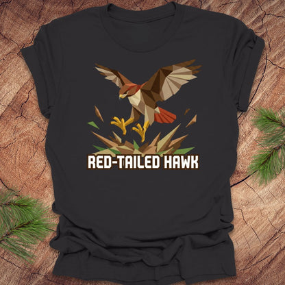 Dark gray t-shirt with a red-tailed hawk design on a wooden surface