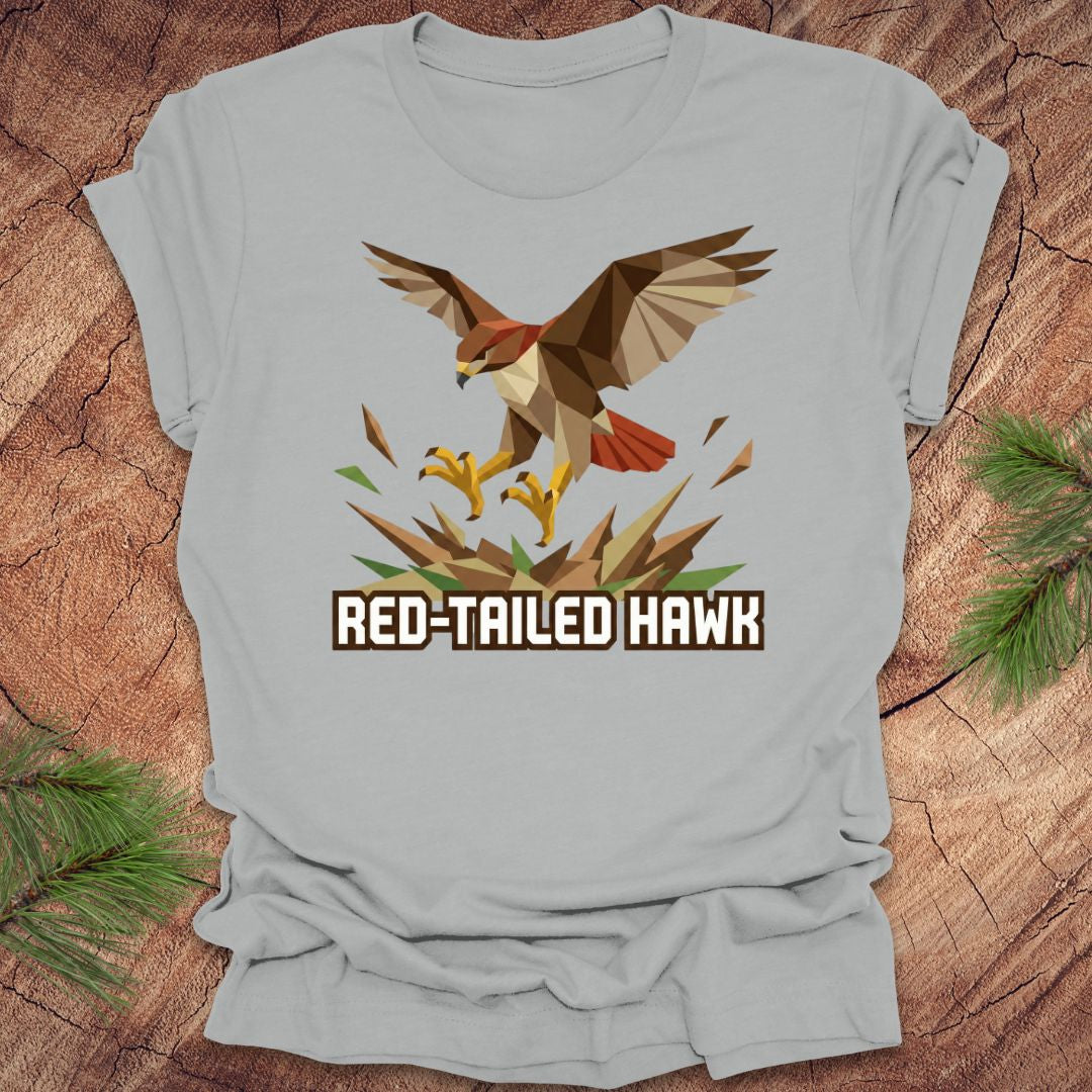 Gray t-shirt with a red-tailed hawk design on a wooden surface