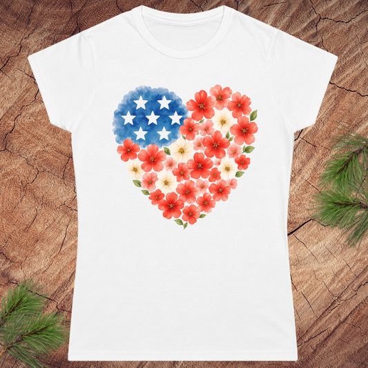 White t-shirt with a heart design featuring American flag stars and red flowers on a wooden surface.
